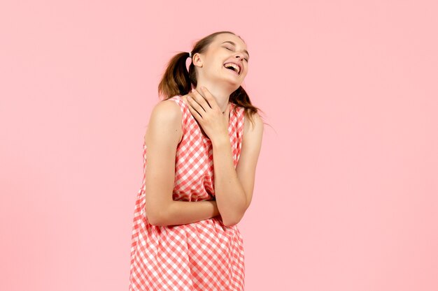 niña en lindo vestido rosa con expresión de risa en rosa