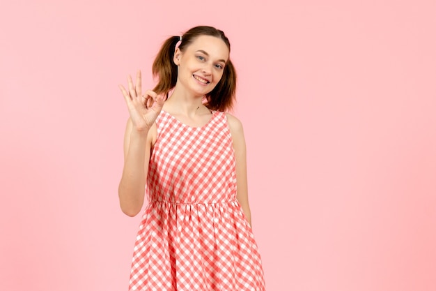 niña en lindo vestido rosa con expresión sonriente en rosa