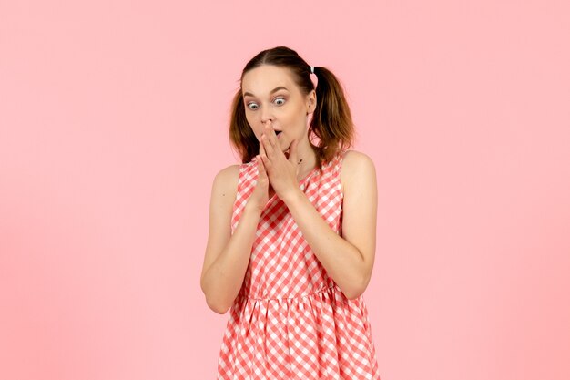 niña en lindo vestido rosa con expresión de sorpresa en rosa