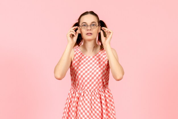 niña en lindo vestido rosa con gafas de sol ópticas en rosa