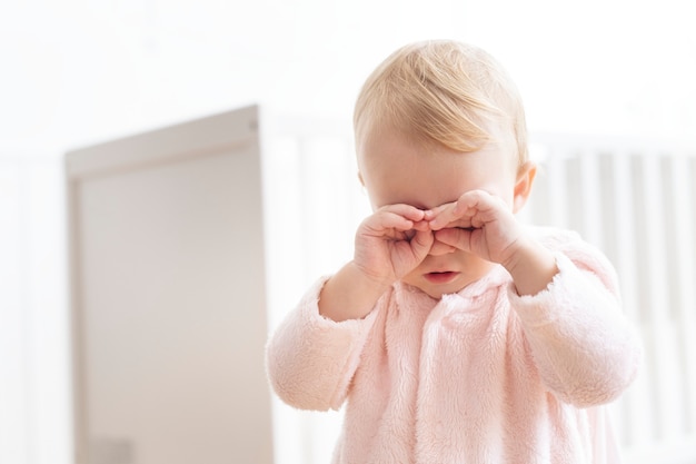 Niña llorando y frotándose los ojos