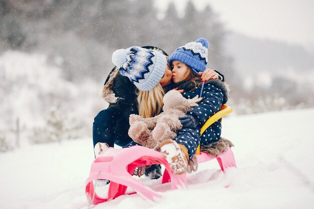 Niña con madre jugando en un parque de invierno