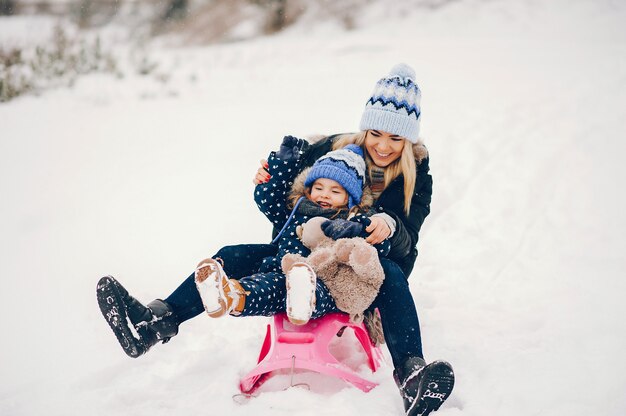 Niña con madre jugando en un parque de invierno