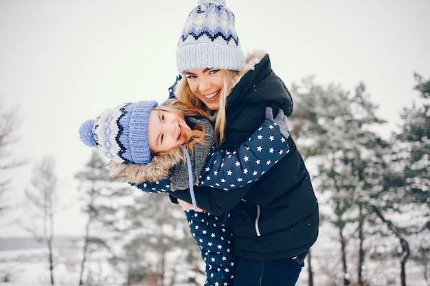 Niña con madre jugando en un parque de invierno