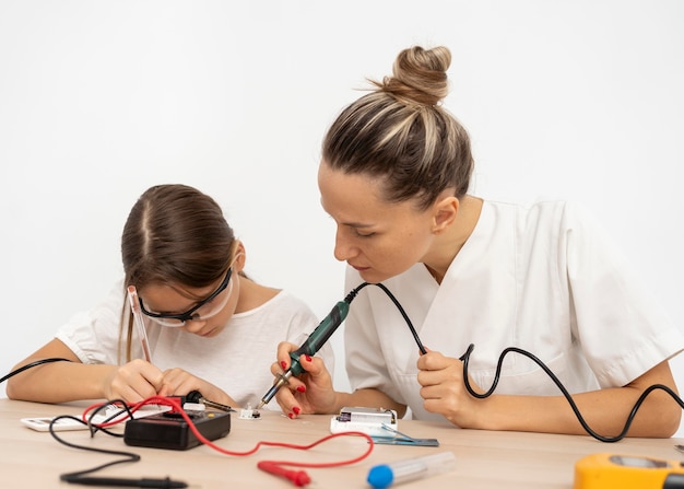 Foto gratuita niña y maestra haciendo experimentos científicos