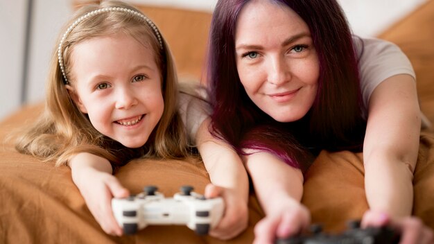 Niña y mamá jugando con joystick