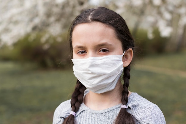 Niña con máscara médica al aire libre