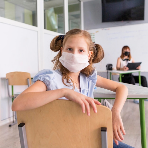 Foto gratuita niña con una mascarilla durante la pandemia