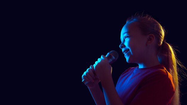 Niña con micrófono en luz de neón