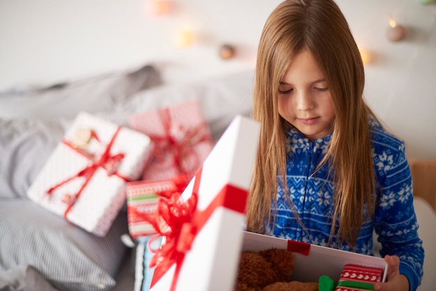 Niña mirando dentro del regalo de Navidad