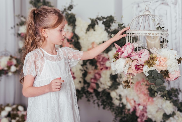 Niña mirando la jaula de flores