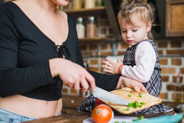 Foto gratuita niña mirando a la madre cosecha haciendo ensalada