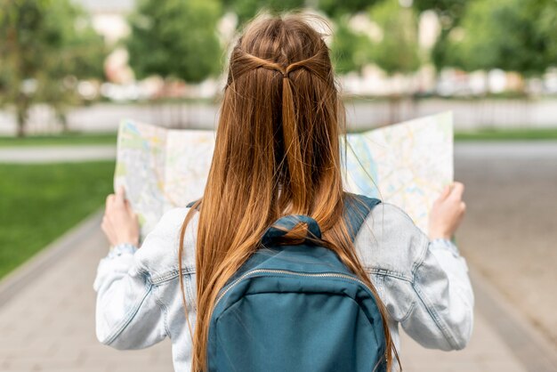 Niña mirando un mapa desde atrás