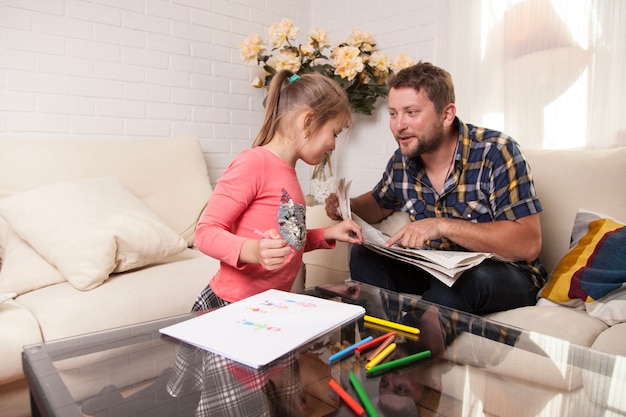 Niña mirando el periódico de su padre