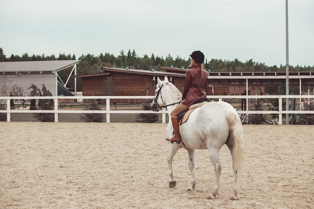 la niña monta un caballo