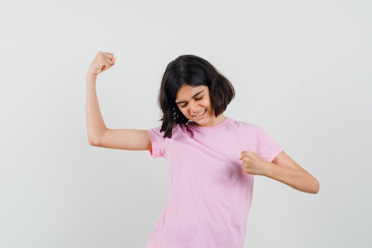 Foto gratuito niña mostrando gesto ganador en camiseta rosa y con suerte. vista frontal.