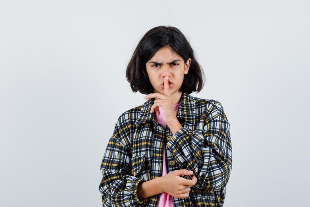 Niña mostrando gesto de silencio en camisa, vista frontal de la chaqueta.