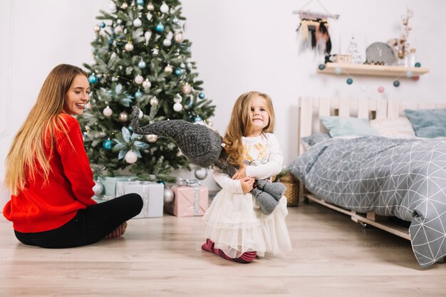 Niña y mujer celebrando navidad en casa