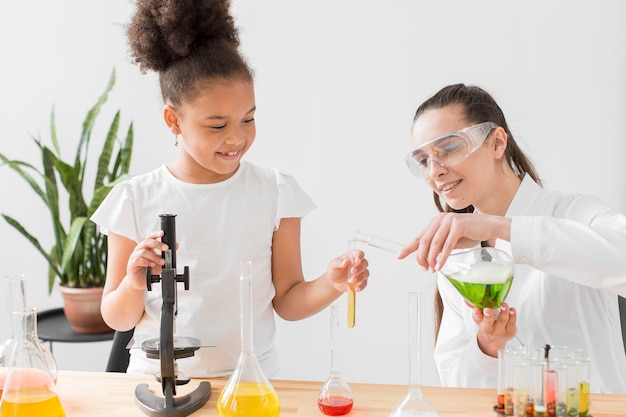 Niña y mujer científico aprendiendo química