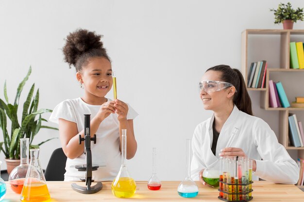 Foto gratuita niña y mujer científico que tiene una clase de ciencias