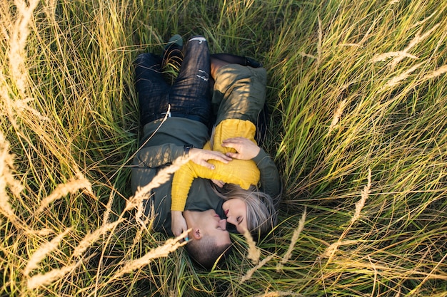 La niña y el niño abrazándose y tumbado en la hierba
