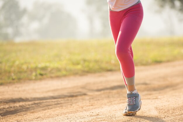 Niña niño feliz corriendo en la pradera en verano en la naturaleza. llamarada cálida de la luz del sol. pequeño asiático corre en un parque. deportes al aire libre y fitness, ejercicio y aprendizaje de competición para el desarrollo de los niños.