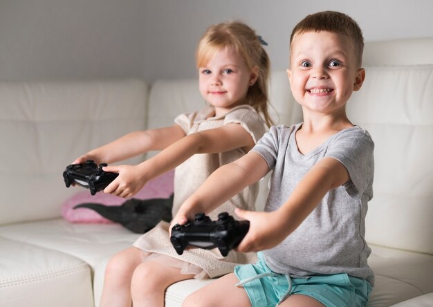 Niña y niño jugando con sus controladores