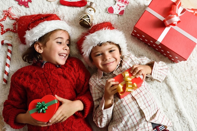 Niña y niño vistiendo el sombrero de papa noel