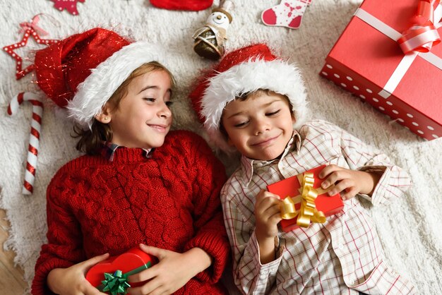 Niña y niño vistiendo el sombrero de papa noel