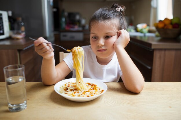 Foto gratuita niña no contenta con plato de pasta