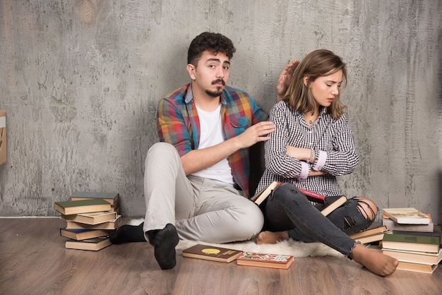 Foto gratuita niña ofendida por el hombre rodeado de libros