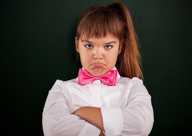 Niña ofendida con pajarita rosa