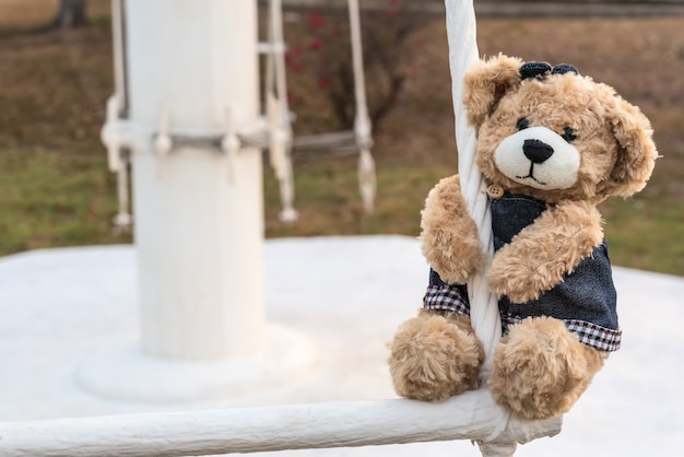 Niña osito de peluche colgando en el patio de recreo