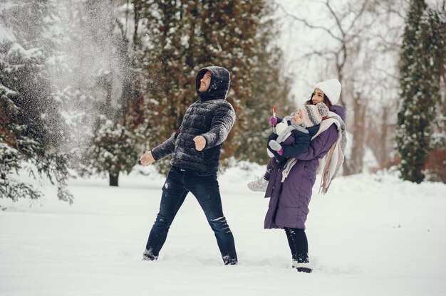 Niña con padres en un parque de invierno