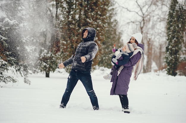 Niña con padres en un parque de invierno