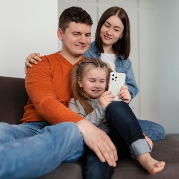 Niña y padres sonrientes de tiro medio