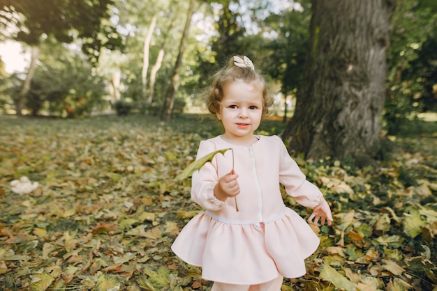 Niña en un parque en un vestido rosa jugando