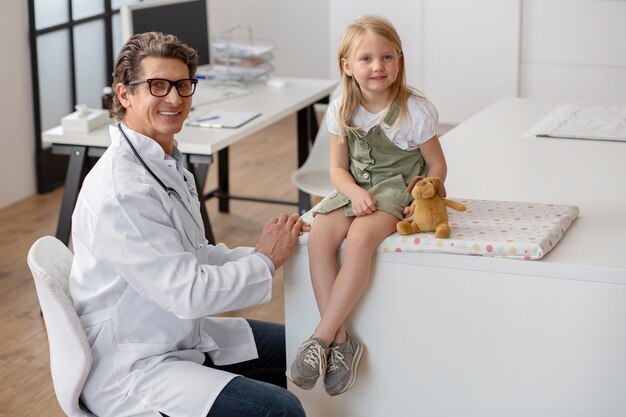 Foto gratuita niña en el pediatra para una consulta con su médico