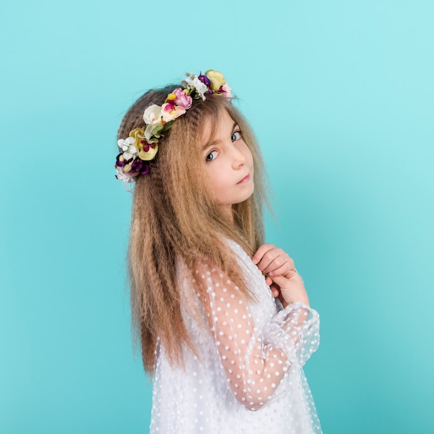Foto gratuita niña pensativa en guirnalda de flores