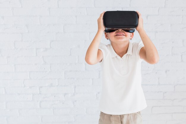 Niña pequeña adorable divirtiéndose con gafas de realidad virtual