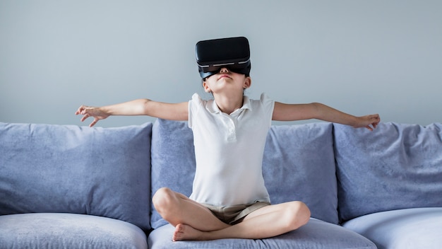 Niña pequeña adorable divirtiéndose con gafas de realidad virtual