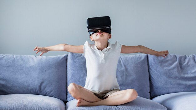 Niña pequeña adorable divirtiéndose con gafas de realidad virtual