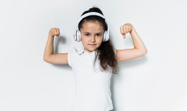 Niña pequeña adorable escuchando música con cascos