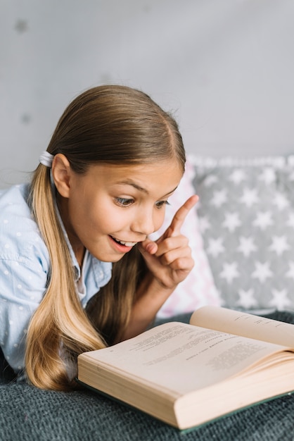 Niña pequeña adorable leyendo un libro