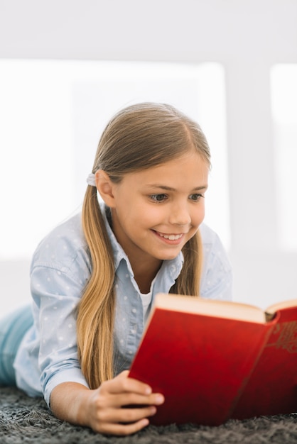 Niña pequeña adorable leyendo un libro