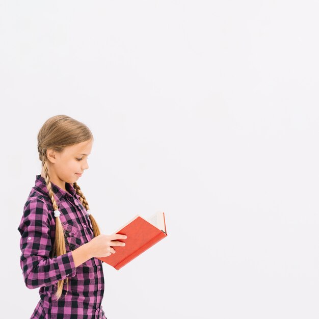 Niña pequeña adorable leyendo un libro