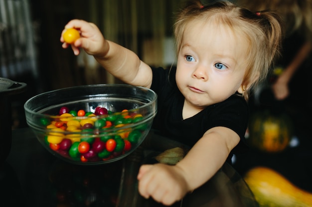 Foto gratuita niña pequeña con un caramelo en la mano