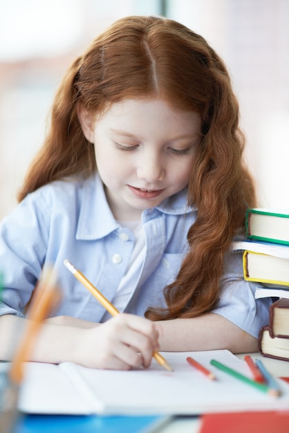 Niña pequeña dibujando en el colegio