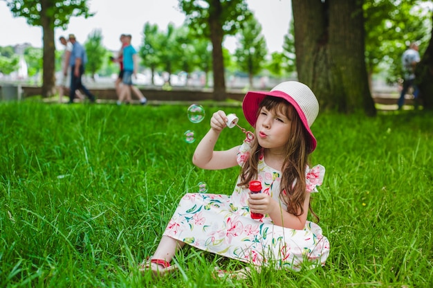 Niña pequeña haciendo burbujas con un pompero