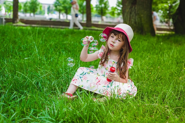 Niña pequeña haciendo burbujas con un pompero